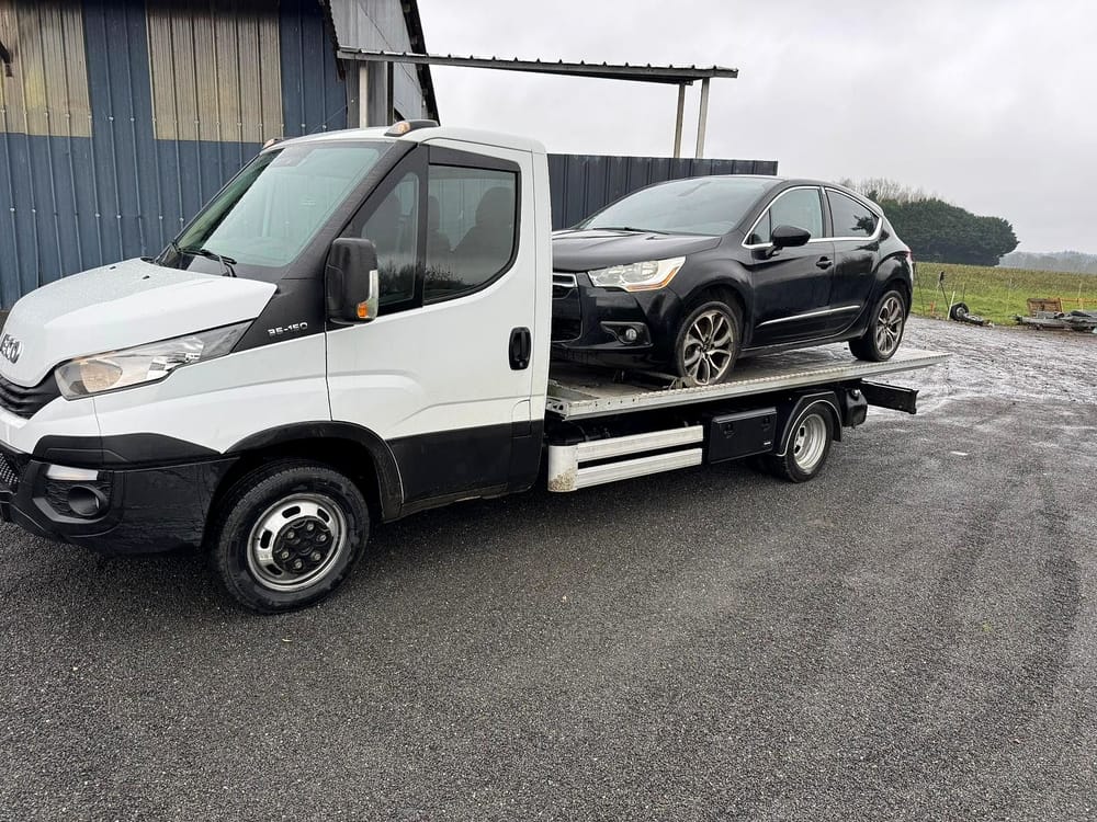 Une voiture chargée sur le plateau du camion blanc de Darel Services