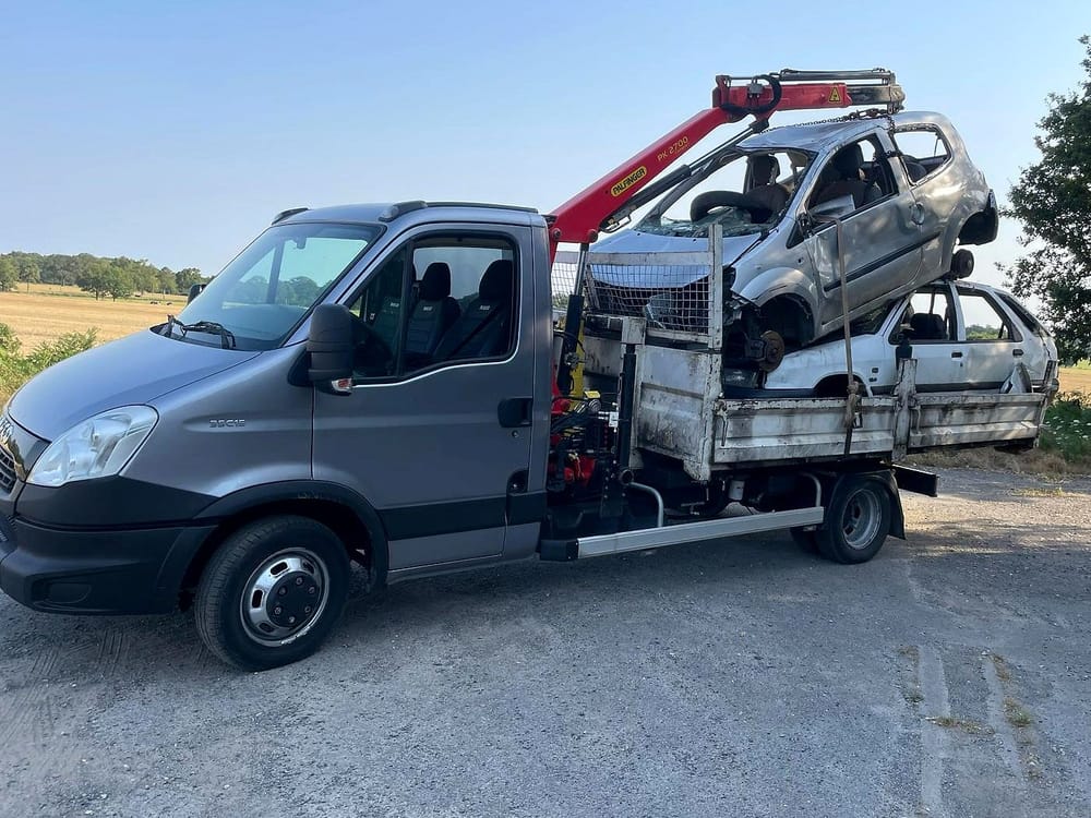 La grue du camion soulève une voiture accidentée pour la poser sur le plateau