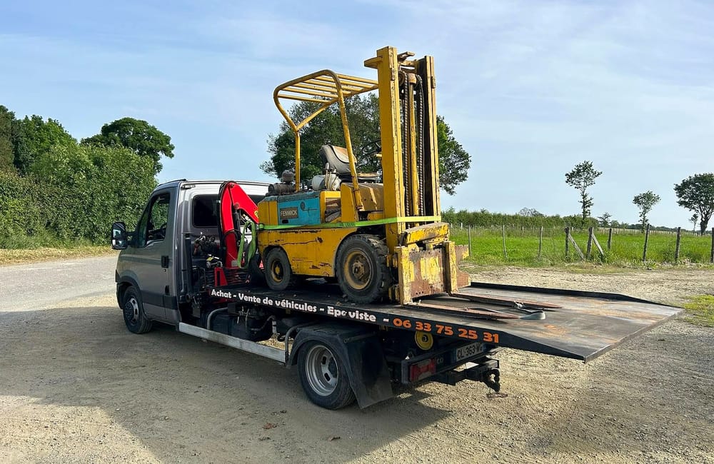 Un chariot élévateur hors d'usage sanglé sur le plateau du camion