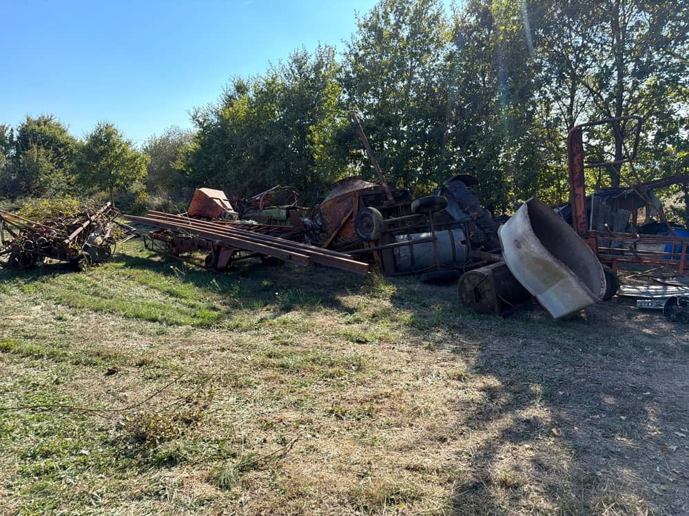 Ferraille et vieux matériel agricole au fond d'un terrain